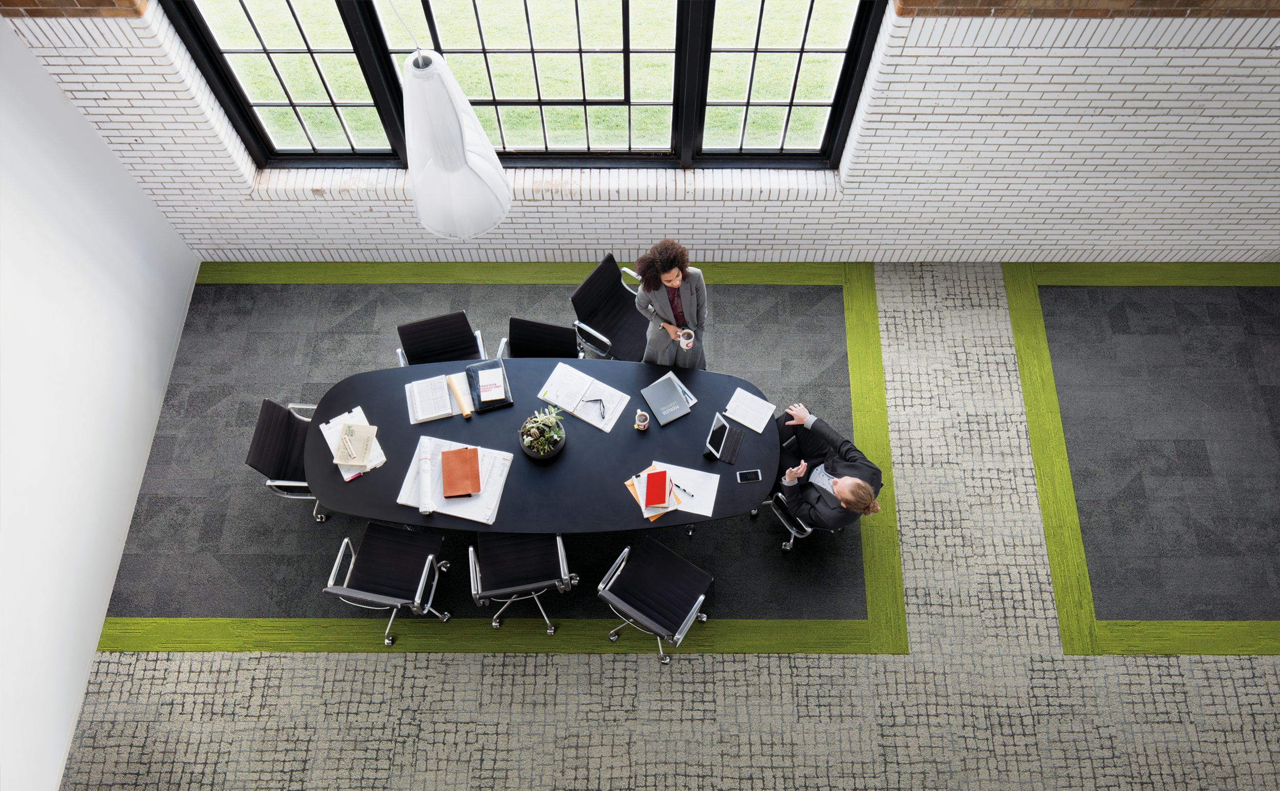 Interface Paver and Sett in Stone carpet tile with UR501 plank carpet tile in overhead view of meeting area with man and women conversating image number 3